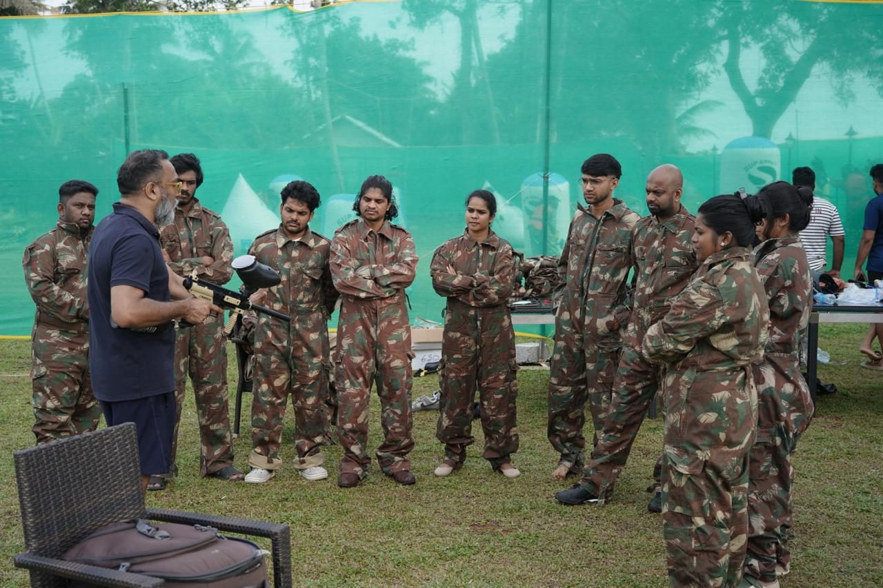 A guide briefing the team before a paintball game