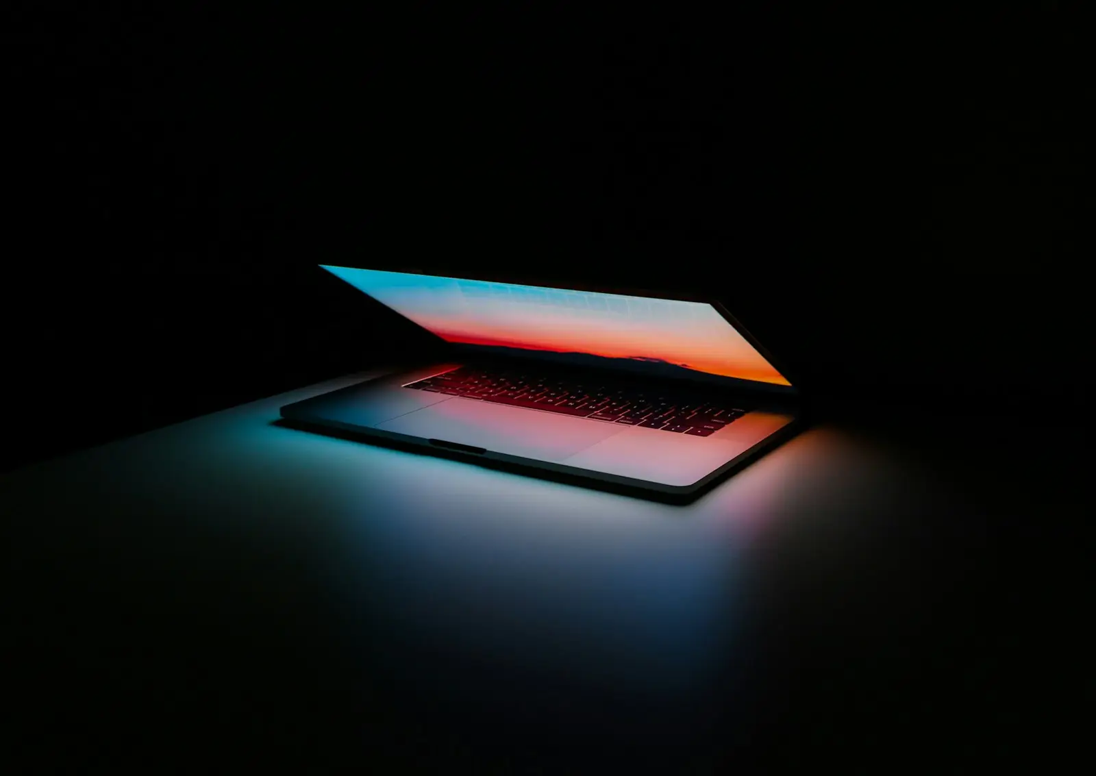 A laptop glowing in a dark room